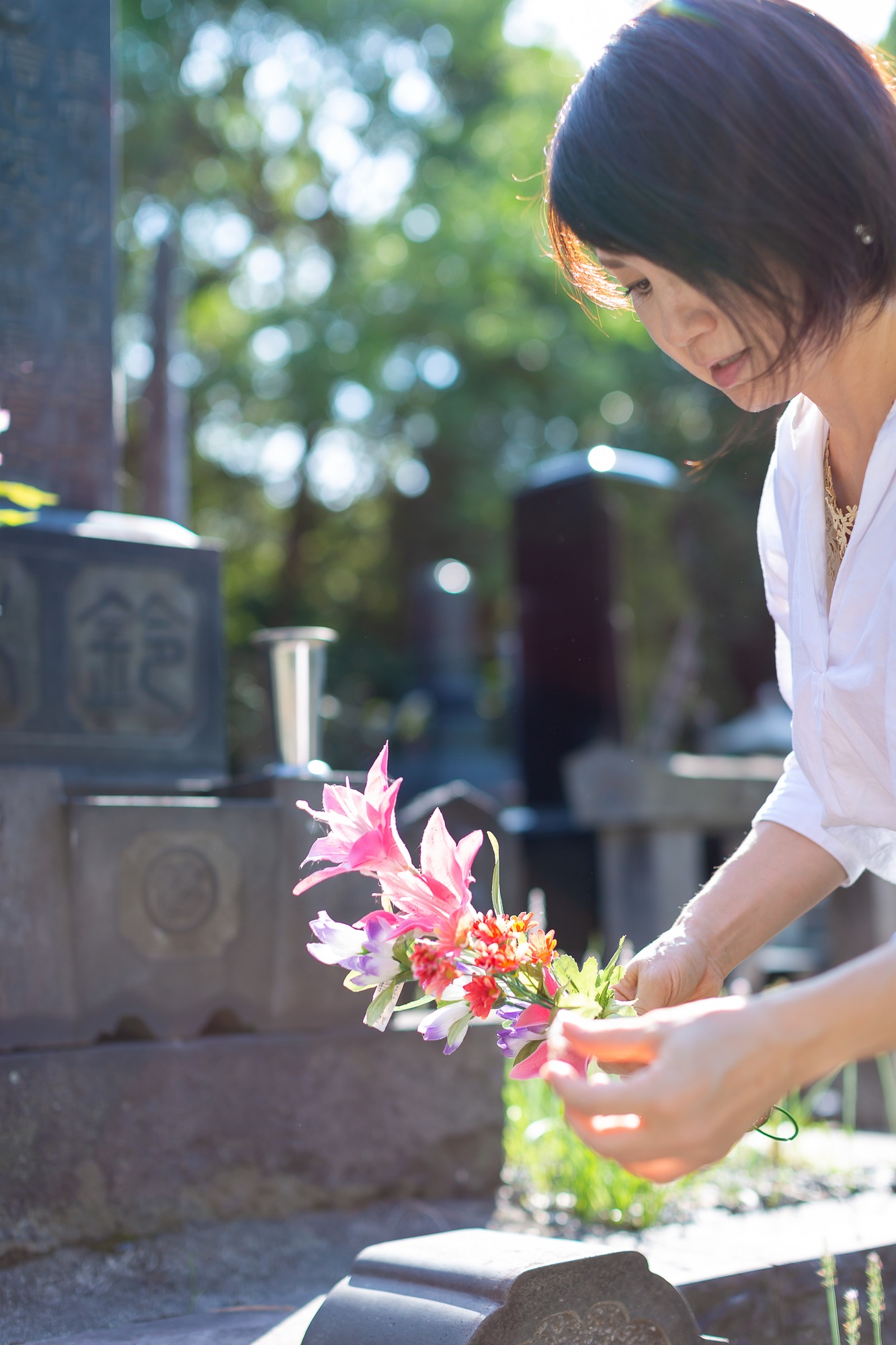 墓前に花を供える女性